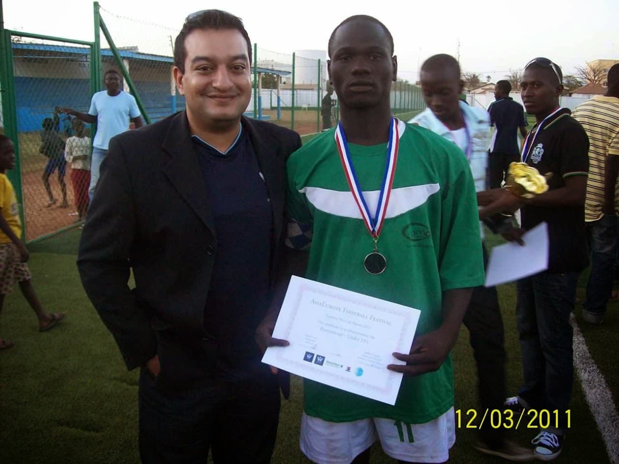 Majid Lavji presenting a medal and certificate to a young player in green kit, March 2011